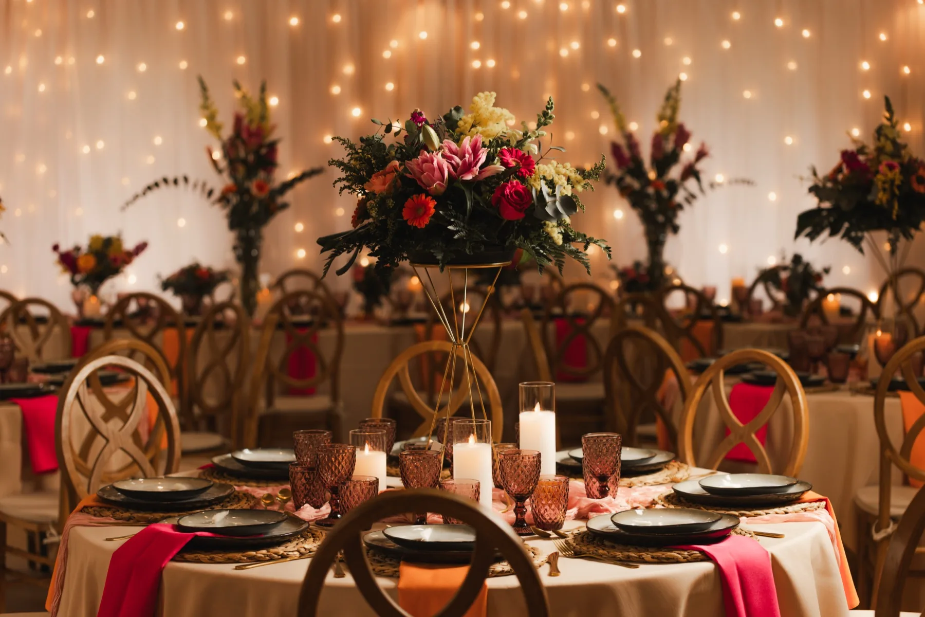 Table de réception dressée avec fleurs, bougies et guirlandes lumineuses
