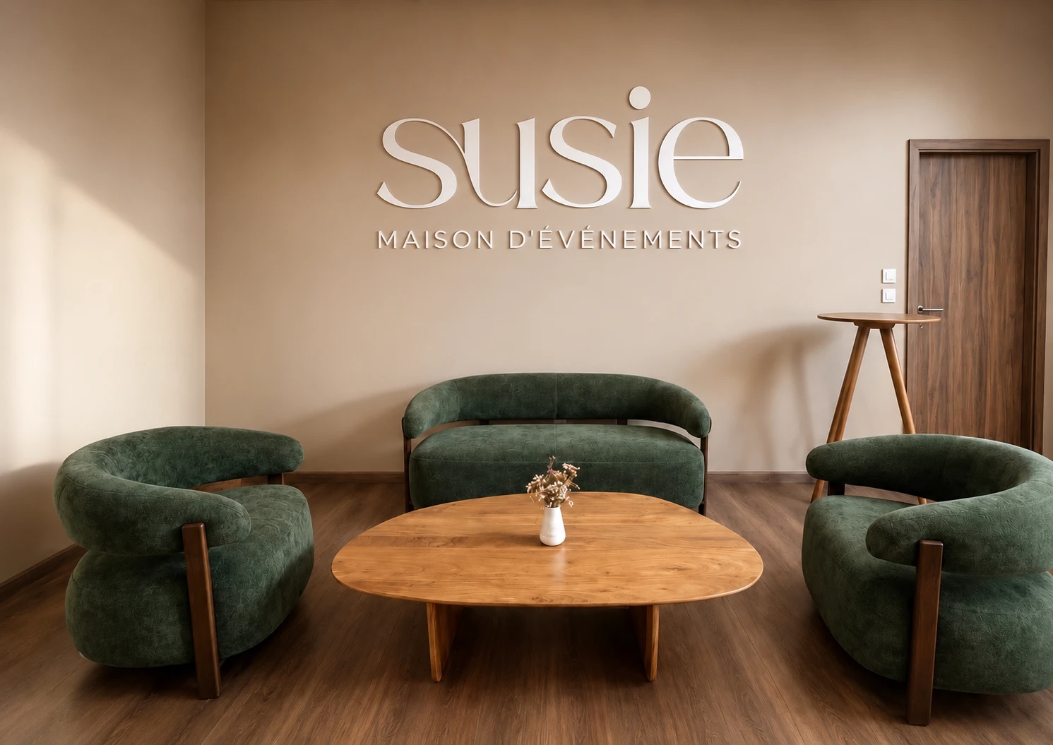 Le showroom de Susie, maison d'événements : l'enseigne, des fauteuils verts et une table basse en bois
